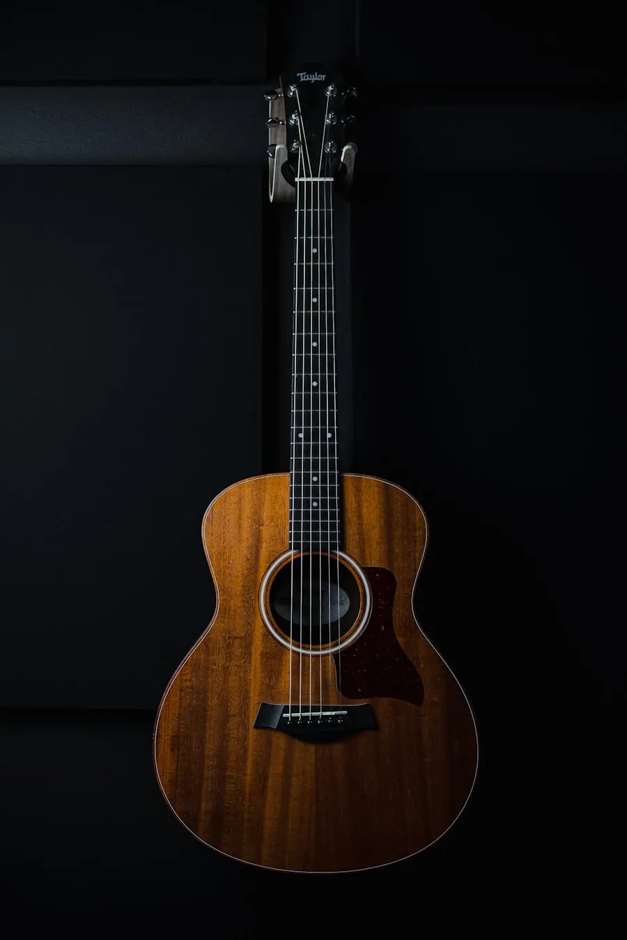Guitarra colgada en pared negra, placeholder de stock